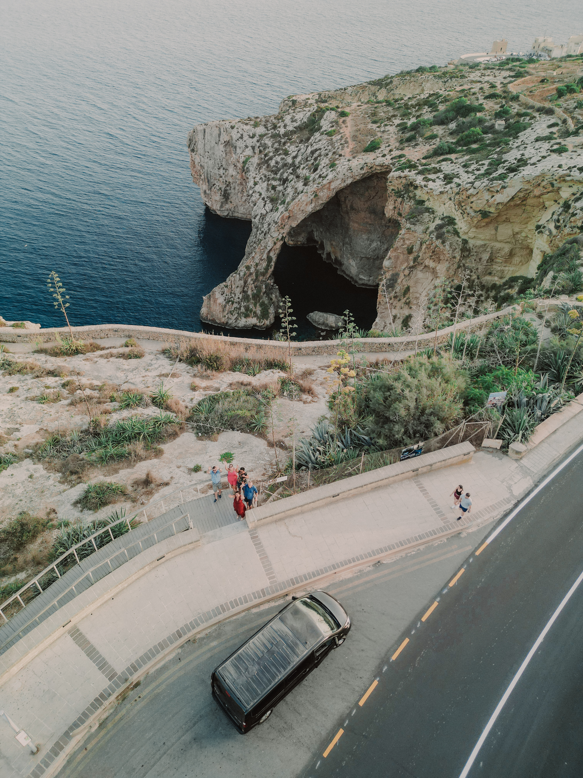 Aerial view of a van driving along a Maltese coastal road