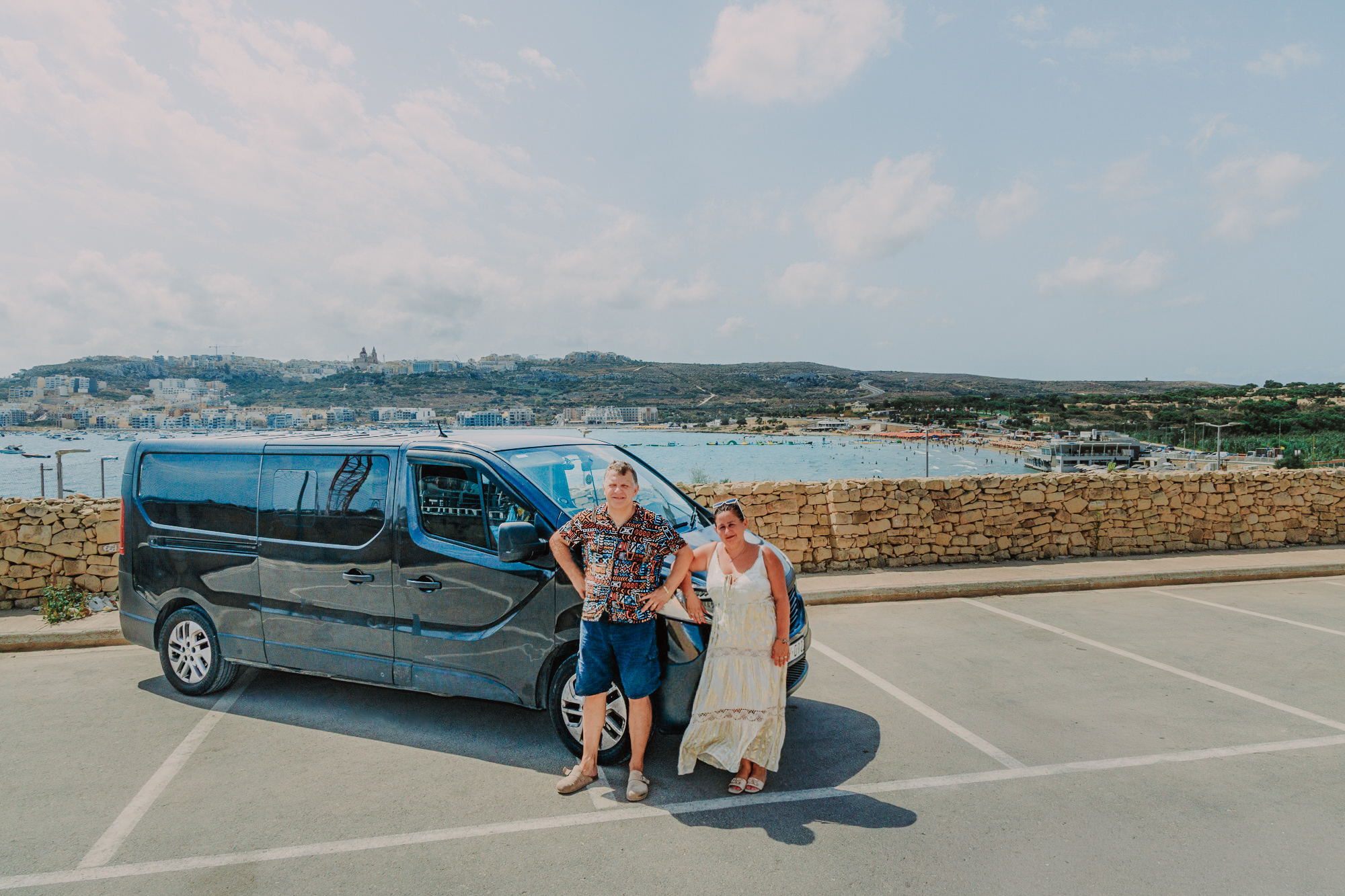 Dianne and Alessandro standing beside the Bullino's Driver van by the Maltese coast